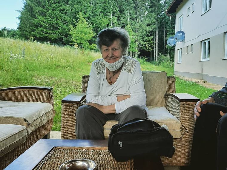 Stanarka sjedi u pletenoj garnituri pred ulazom u dom